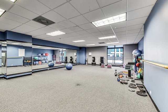 gym with carpet flooring, a paneled ceiling, and baseboards