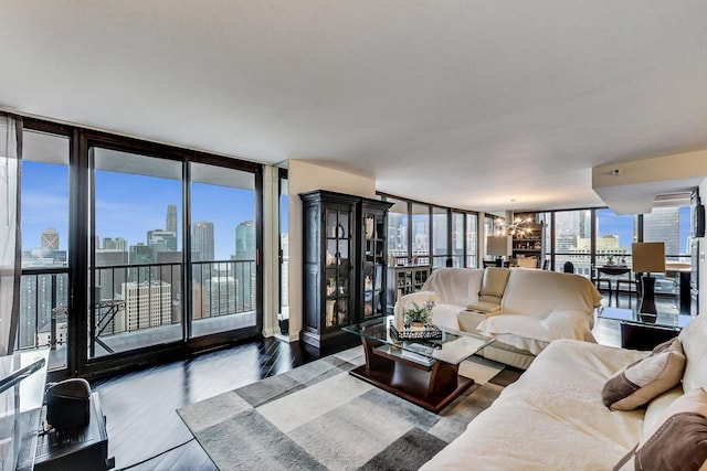 living area featuring a chandelier, a city view, wood finished floors, and floor to ceiling windows