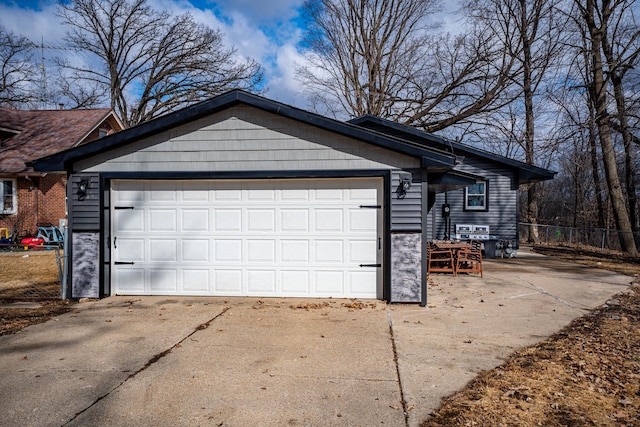 garage with driveway and fence