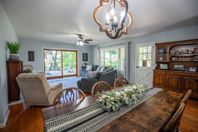 dining area featuring ceiling fan with notable chandelier and wood finished floors