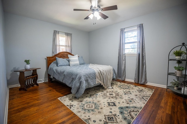 bedroom featuring multiple windows, wood finished floors, and baseboards