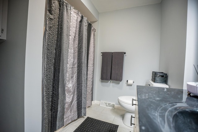 bathroom featuring visible vents, toilet, vanity, tile patterned flooring, and baseboards