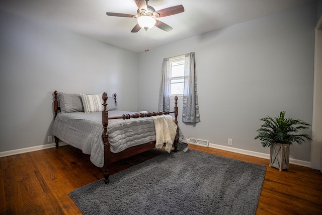 bedroom with wood finished floors, visible vents, and baseboards