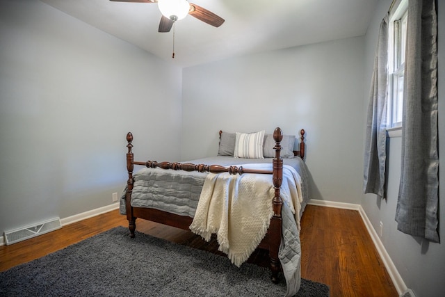 bedroom with visible vents, ceiling fan, baseboards, and wood finished floors