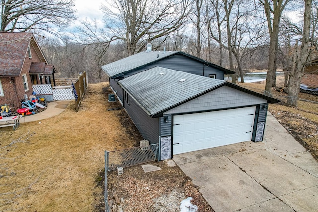 view of property exterior with driveway, stone siding, a garage, and fence