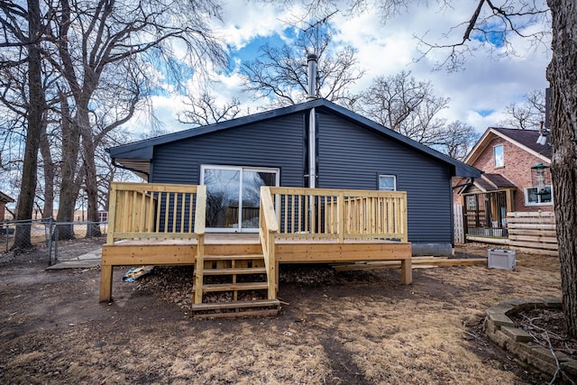 rear view of property with a gate, fence, and a wooden deck