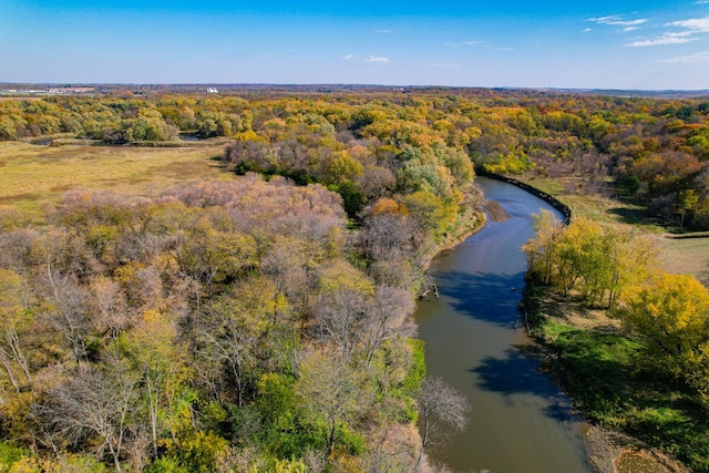 birds eye view of property featuring a water view and a wooded view