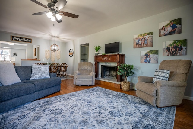 living area with a premium fireplace, wood finished floors, and baseboards