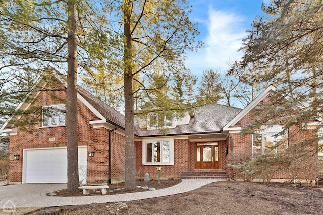 traditional home with brick siding, driveway, and an attached garage