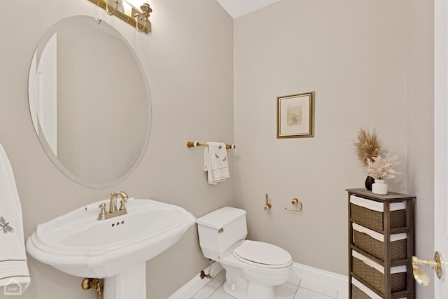 bathroom with toilet, baseboards, a sink, and tile patterned floors