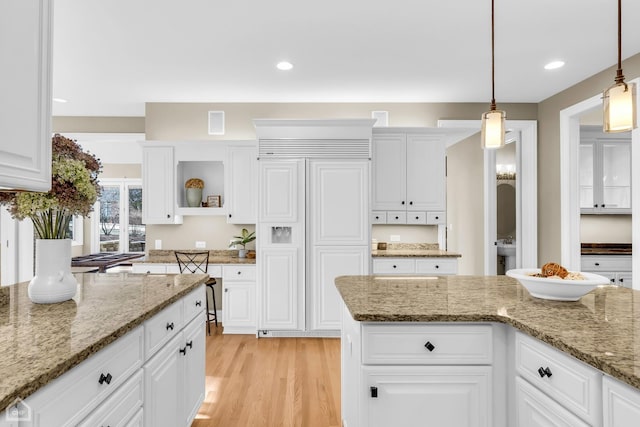 kitchen with hanging light fixtures, paneled built in refrigerator, light wood-style floors, white cabinetry, and open shelves