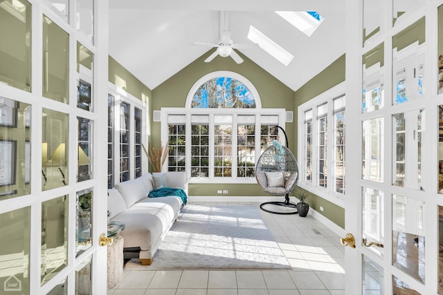 sunroom featuring vaulted ceiling with skylight, a healthy amount of sunlight, and ceiling fan