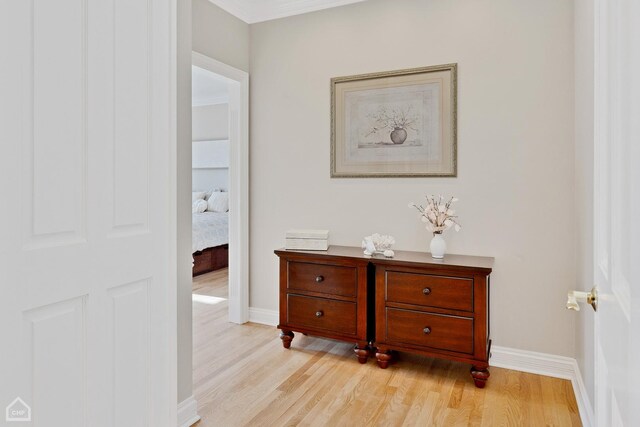 hall with light wood-style flooring and baseboards