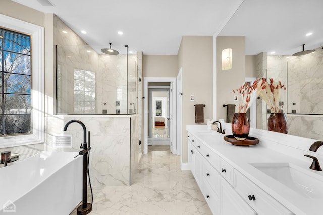 bathroom with marble finish floor, a marble finish shower, a sink, and a soaking tub