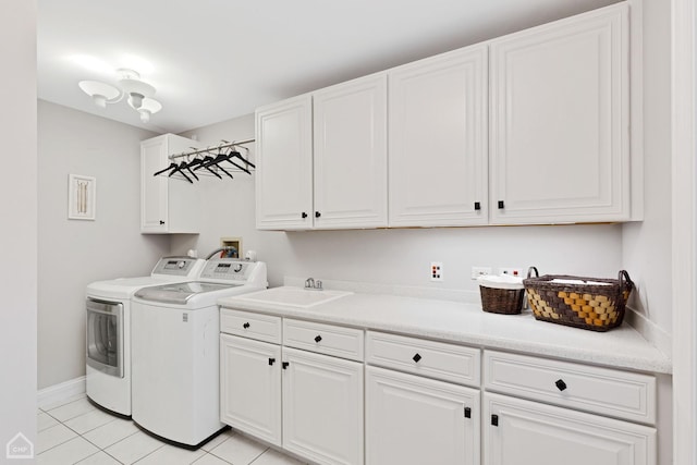 washroom with washer and clothes dryer, light tile patterned floors, cabinet space, a sink, and baseboards