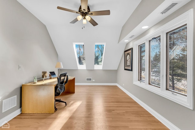 office space featuring light wood-type flooring, visible vents, and baseboards