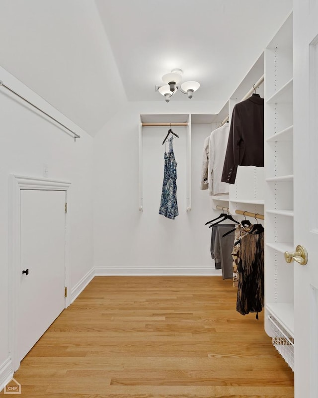 walk in closet with lofted ceiling and light wood-style floors