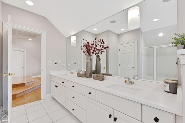 full bath featuring lofted ceiling, a sink, a shower stall, and double vanity