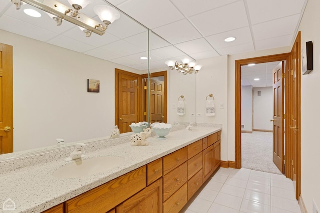 bathroom with double vanity, tile patterned flooring, a sink, and baseboards