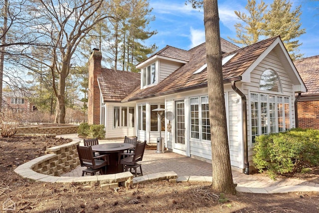 rear view of property with a patio area and a chimney