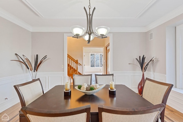 dining space with a notable chandelier, visible vents, stairway, wainscoting, and light wood-type flooring