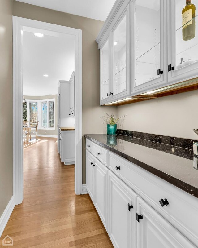 bar featuring light wood-type flooring and baseboards