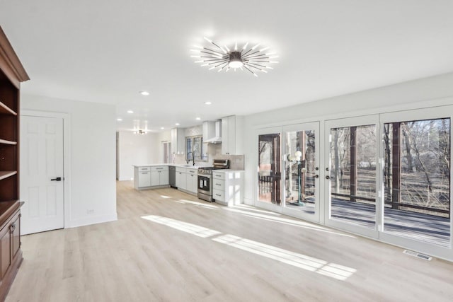 unfurnished living room featuring light wood-style floors, baseboards, visible vents, and recessed lighting