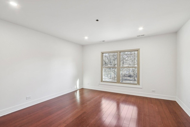 unfurnished room with visible vents, baseboards, dark wood-type flooring, and recessed lighting