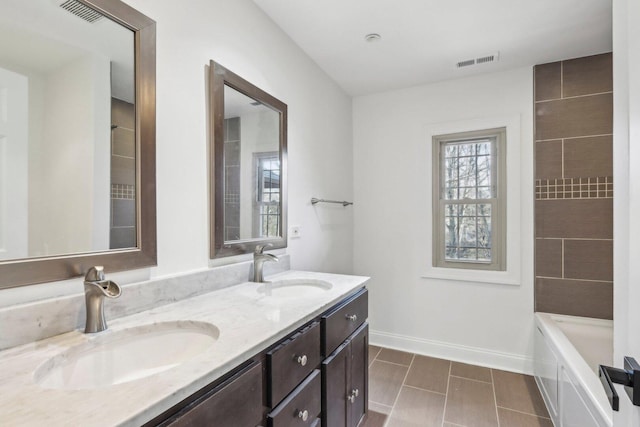 full bath with visible vents, a sink, and baseboards