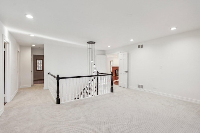 empty room featuring light carpet, visible vents, and recessed lighting