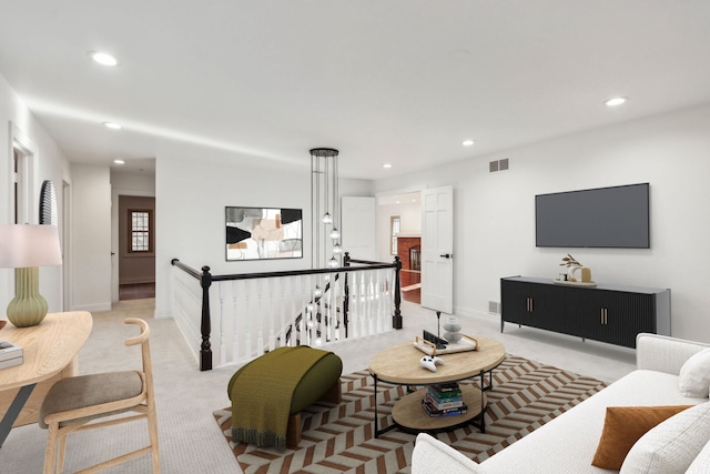 living area featuring baseboards, recessed lighting, visible vents, and light colored carpet