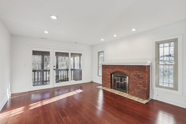 unfurnished living room featuring hardwood / wood-style floors, a fireplace, recessed lighting, and baseboards