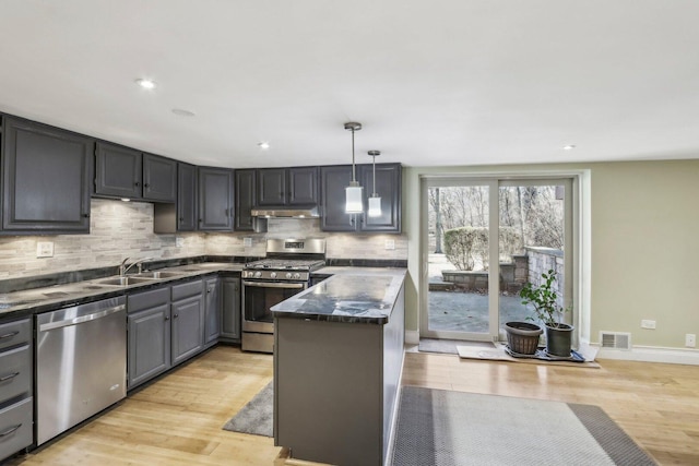 kitchen with under cabinet range hood, visible vents, stainless steel appliances, and light wood finished floors