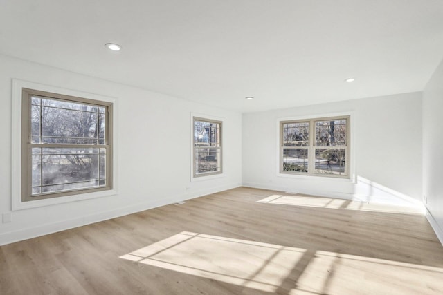 empty room featuring recessed lighting, baseboards, and wood finished floors