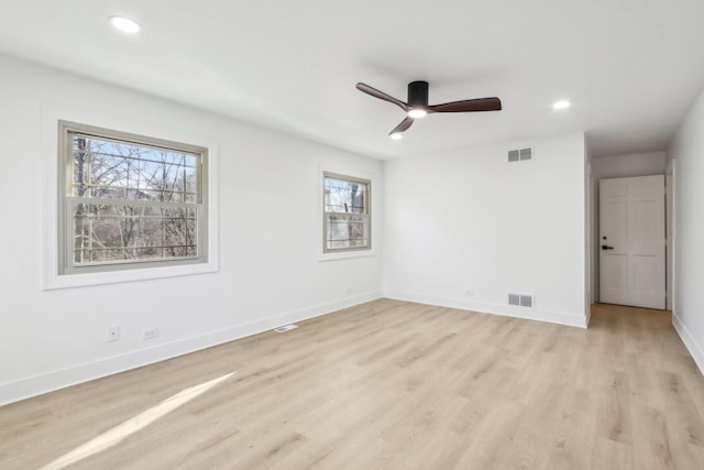 unfurnished room featuring light wood-style floors, baseboards, visible vents, and recessed lighting