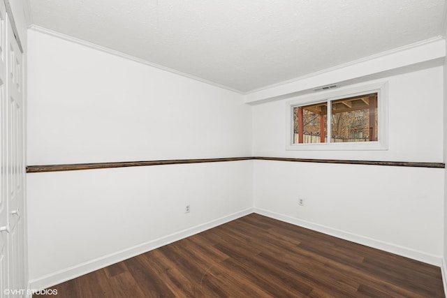 unfurnished room with dark wood-style flooring, visible vents, a textured ceiling, and baseboards