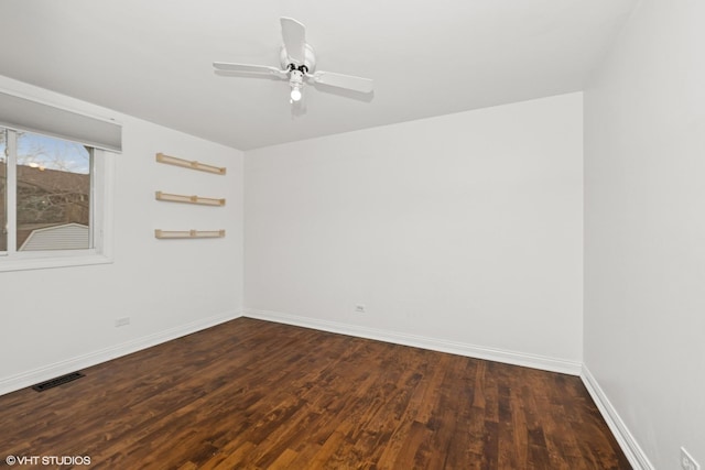 empty room featuring a ceiling fan, baseboards, visible vents, and dark wood-style flooring