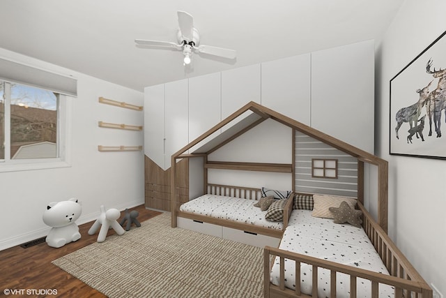 bedroom featuring visible vents, baseboards, and wood finished floors