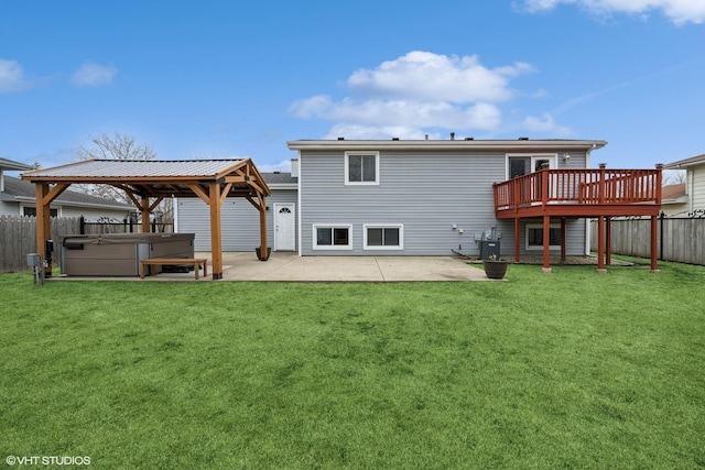 rear view of property with a yard, a patio, a hot tub, a gazebo, and fence