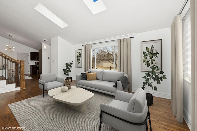 living room with vaulted ceiling with skylight, wood finished floors, baseboards, stairway, and an inviting chandelier