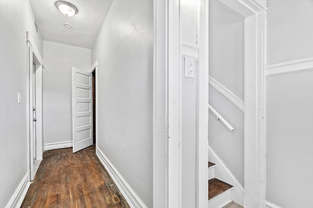 corridor featuring stairs, baseboards, and wood finished floors