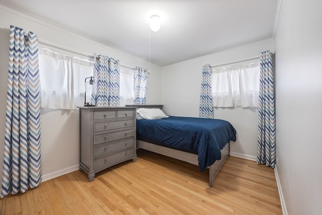 bedroom with light wood finished floors, baseboards, and ornamental molding