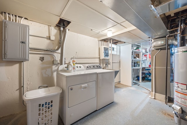 clothes washing area featuring washing machine and dryer, laundry area, electric panel, and gas water heater