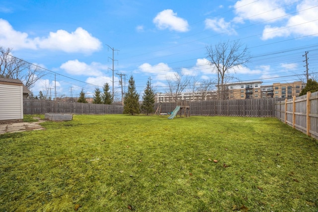 view of yard with a fenced backyard and a playground