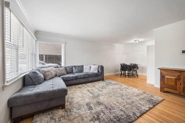 living area with baseboards, crown molding, and wood finished floors