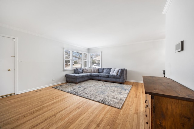 living room with light wood finished floors, visible vents, ornamental molding, and baseboards