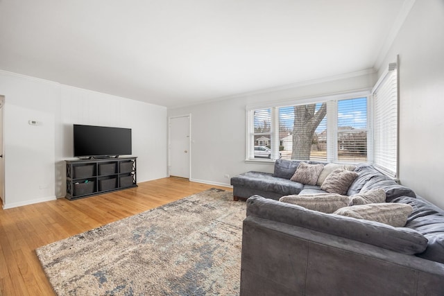 living room featuring crown molding, baseboards, and wood finished floors