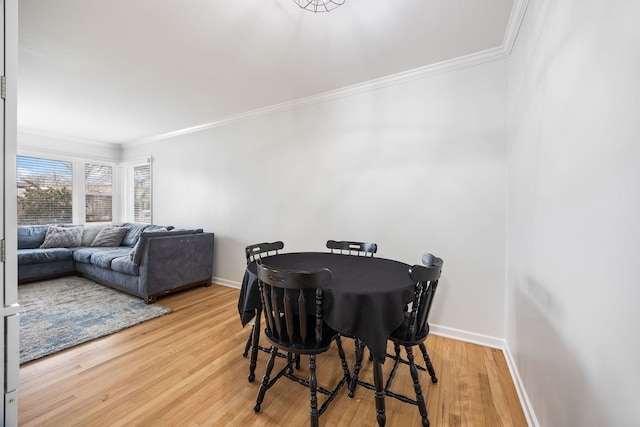 dining room featuring ornamental molding, baseboards, and wood finished floors