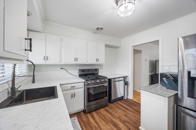 kitchen with visible vents, appliances with stainless steel finishes, ornamental molding, white cabinetry, and a sink