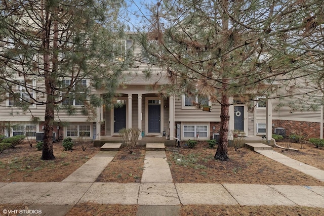 view of front of home featuring covered porch and brick siding